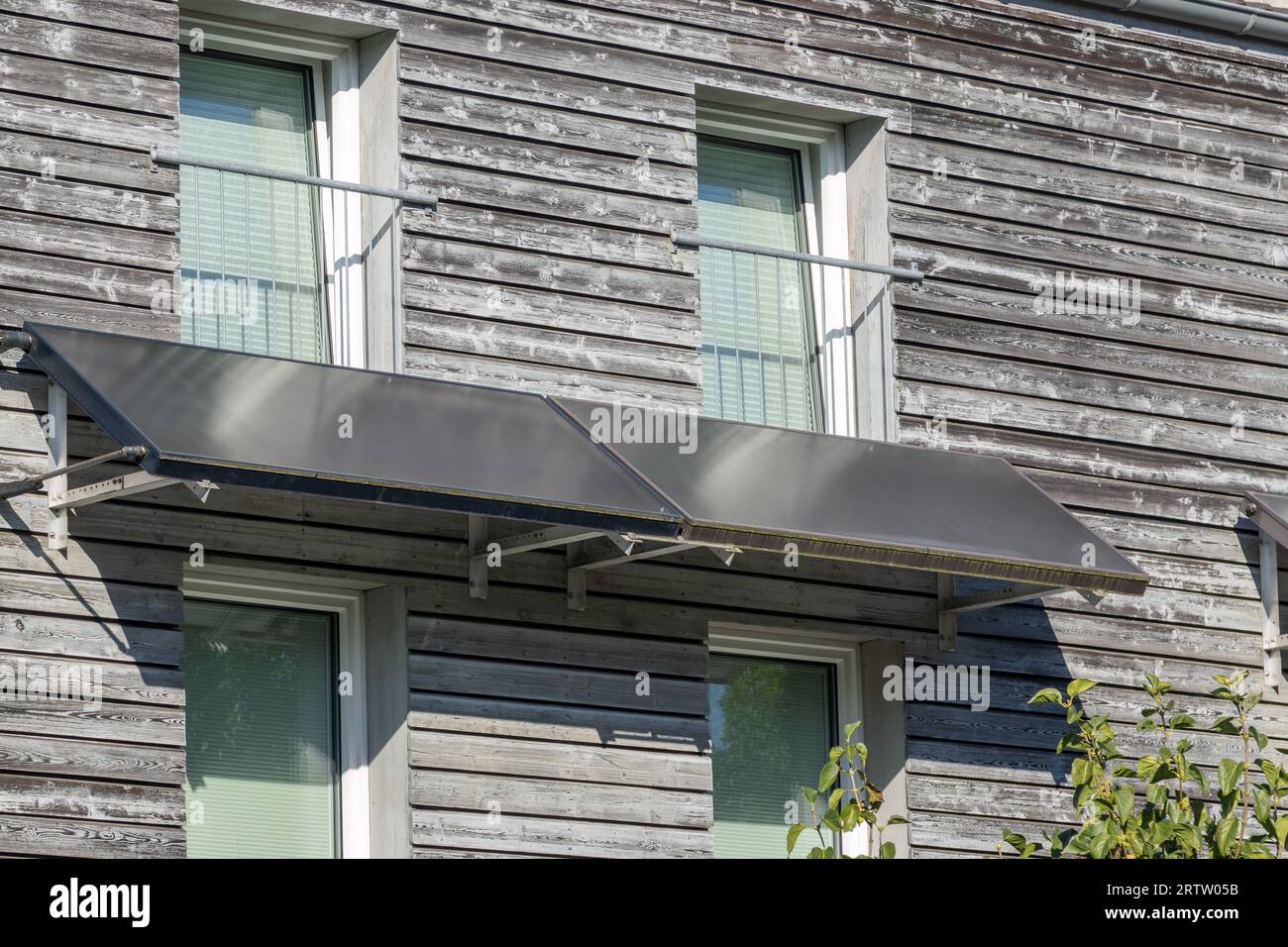 Solarpaneele in einem Wohngebäude mit Holzfassade Stockfoto