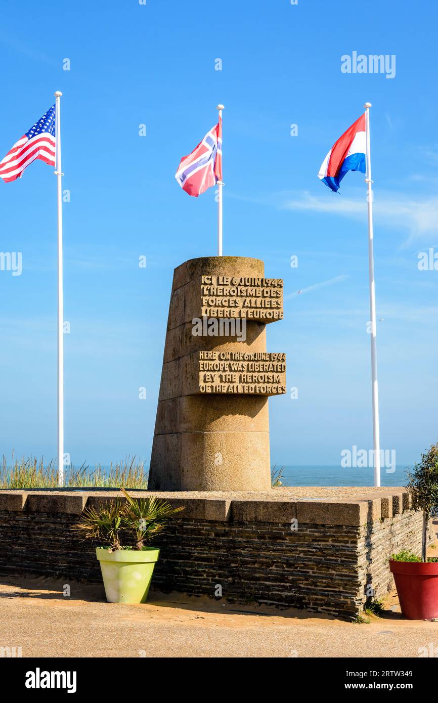 Signaldenkmal in Bernières-sur-Mer, Frankreich, errichtet im Jahr 1950 auf der Anlegestelle der Normandie im Zweiten Weltkrieg am Juno Beach, umgeben von den Flaggen der Alliierten. Stockfoto