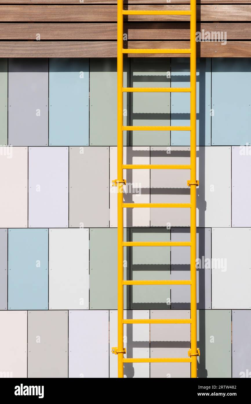 Gelbe Leiter an einer Wand Stockfoto