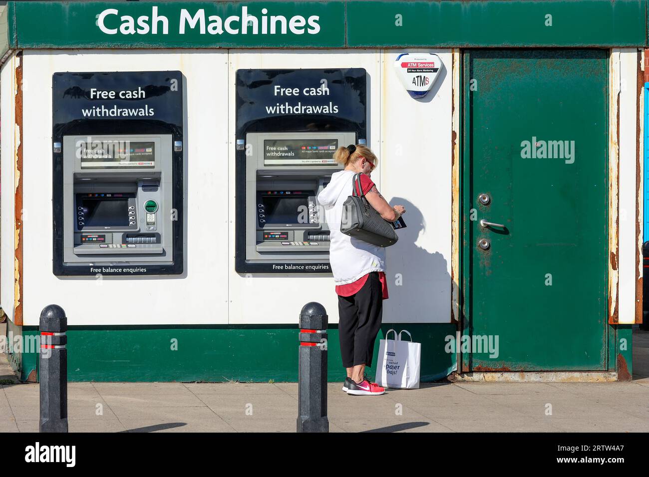 Frau, die einen Geldautomaten benutzt, für kostenlose Bargeldabhebungen, Troon, Schottland, Großbritannien Stockfoto