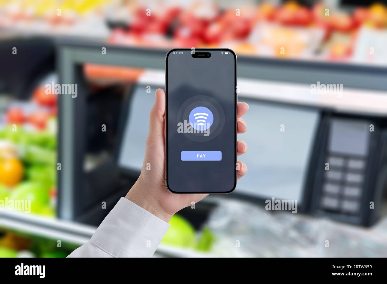 Frau hält ein Smartphone und zeigt eine NFC-Zahlung an. Lebensmittelmarkt im Hintergrund. Konzept für schnelleres und effizienteres Einkaufen mit Apps Stockfoto