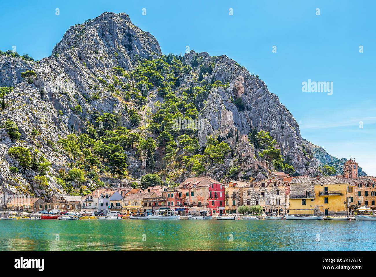 Malerischer Blick auf die Altstadt von Omis in Kroatien mit der Adria und Bergen mit Kiefern im Hintergrund Stockfoto