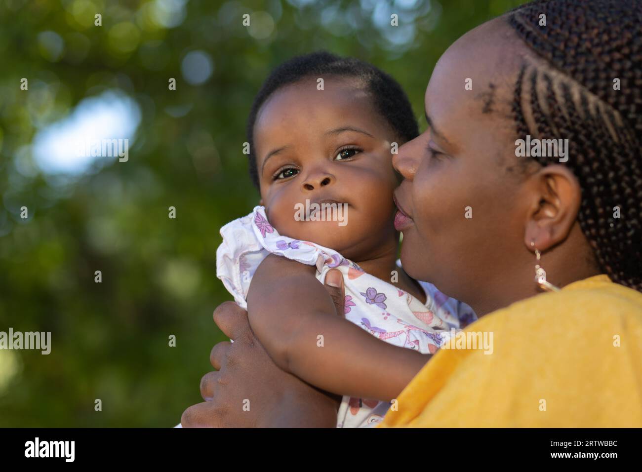 Nahaufnahme einer schwarzen Mutter, die ihre kleine Tochter im Freien hält Stockfoto