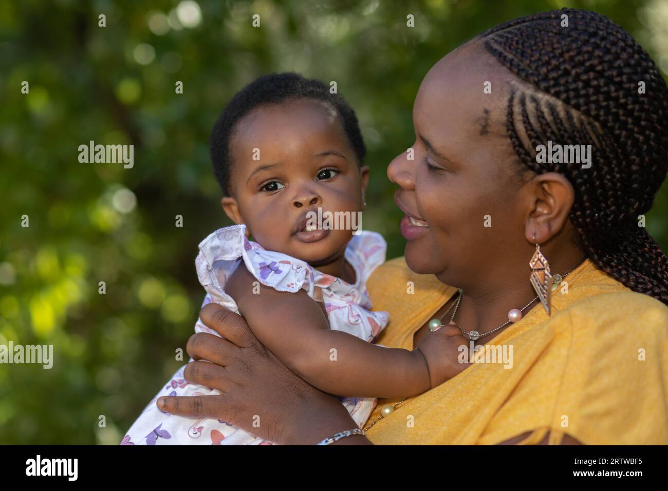 Nahaufnahme einer schwarzen Mutter, die ihre kleine Tochter im Freien hält Stockfoto