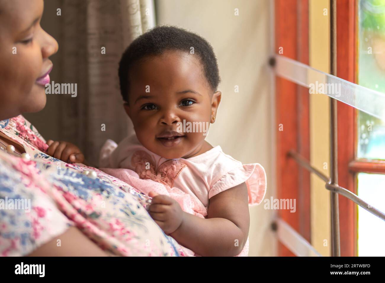 Nahporträt einer jungen schwarzen Mutter, die ihre kleine Tochter hält Stockfoto