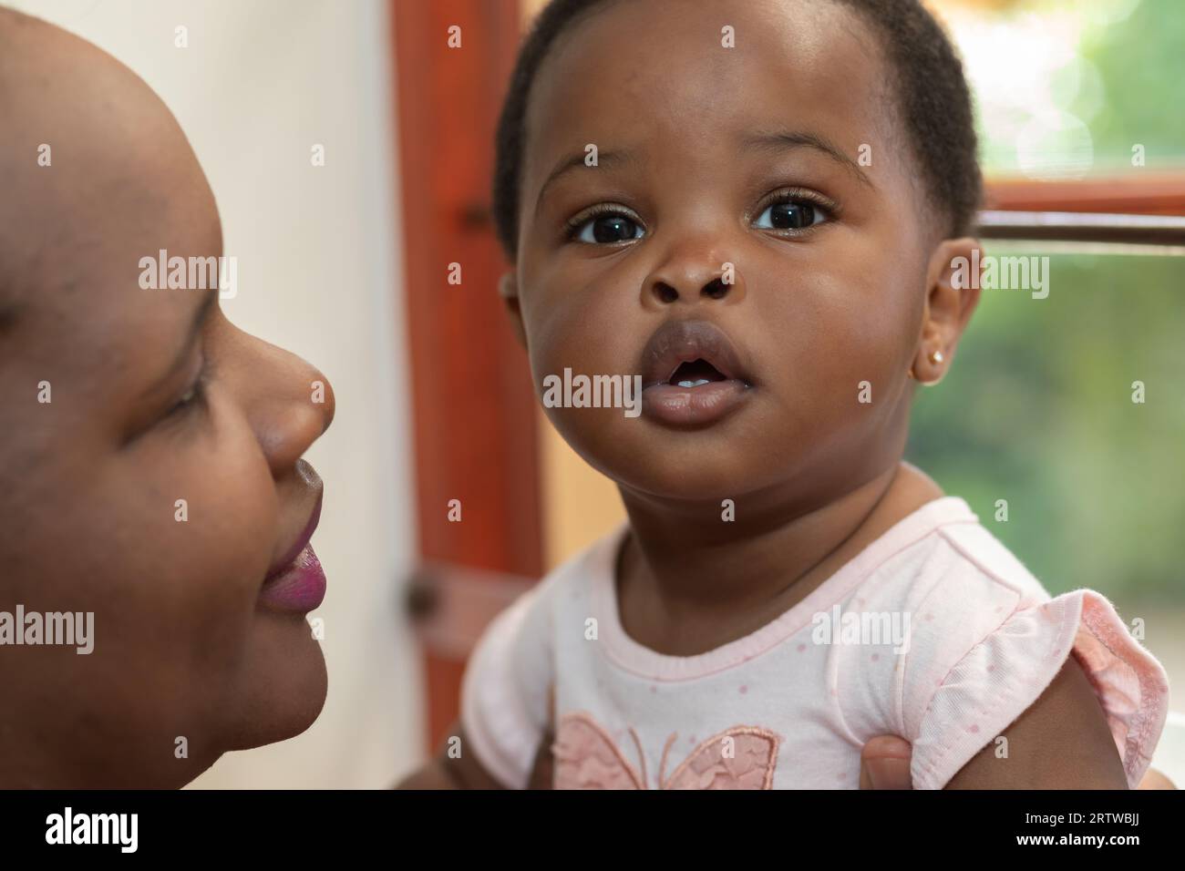 Nahporträt einer jungen schwarzen Mutter, die ihre kleine Tochter hält Stockfoto