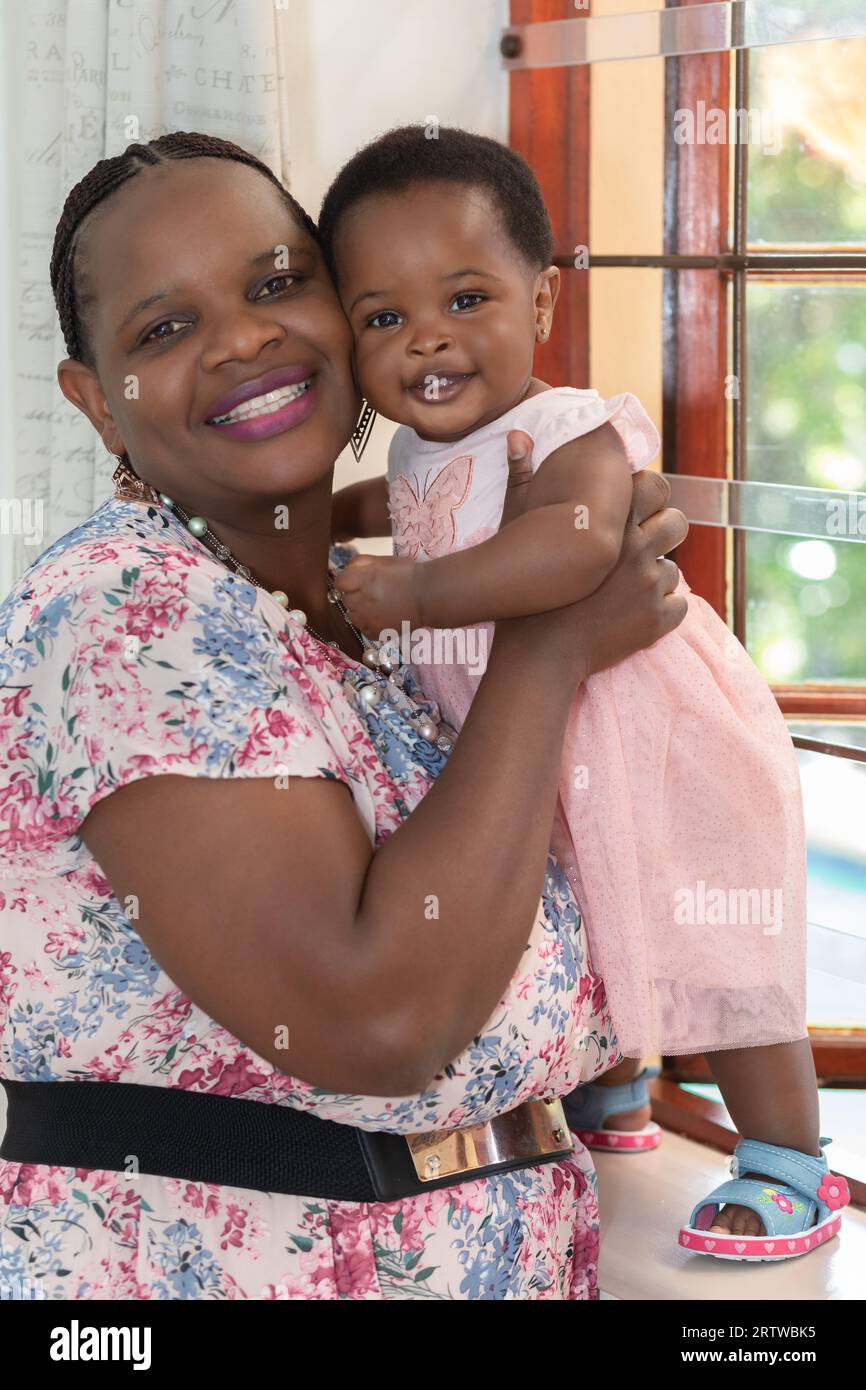 Nahaufnahme einer jungen schwarzen Frau und ihrer kleinen Tochter, die vor der Kamera lächeln Stockfoto