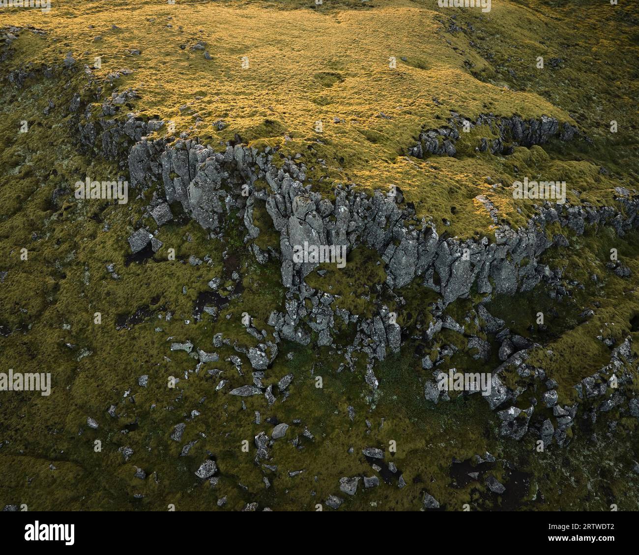 Trockener Grasberggrat mit verwitterten Felsen bei Tageslicht Stockfoto