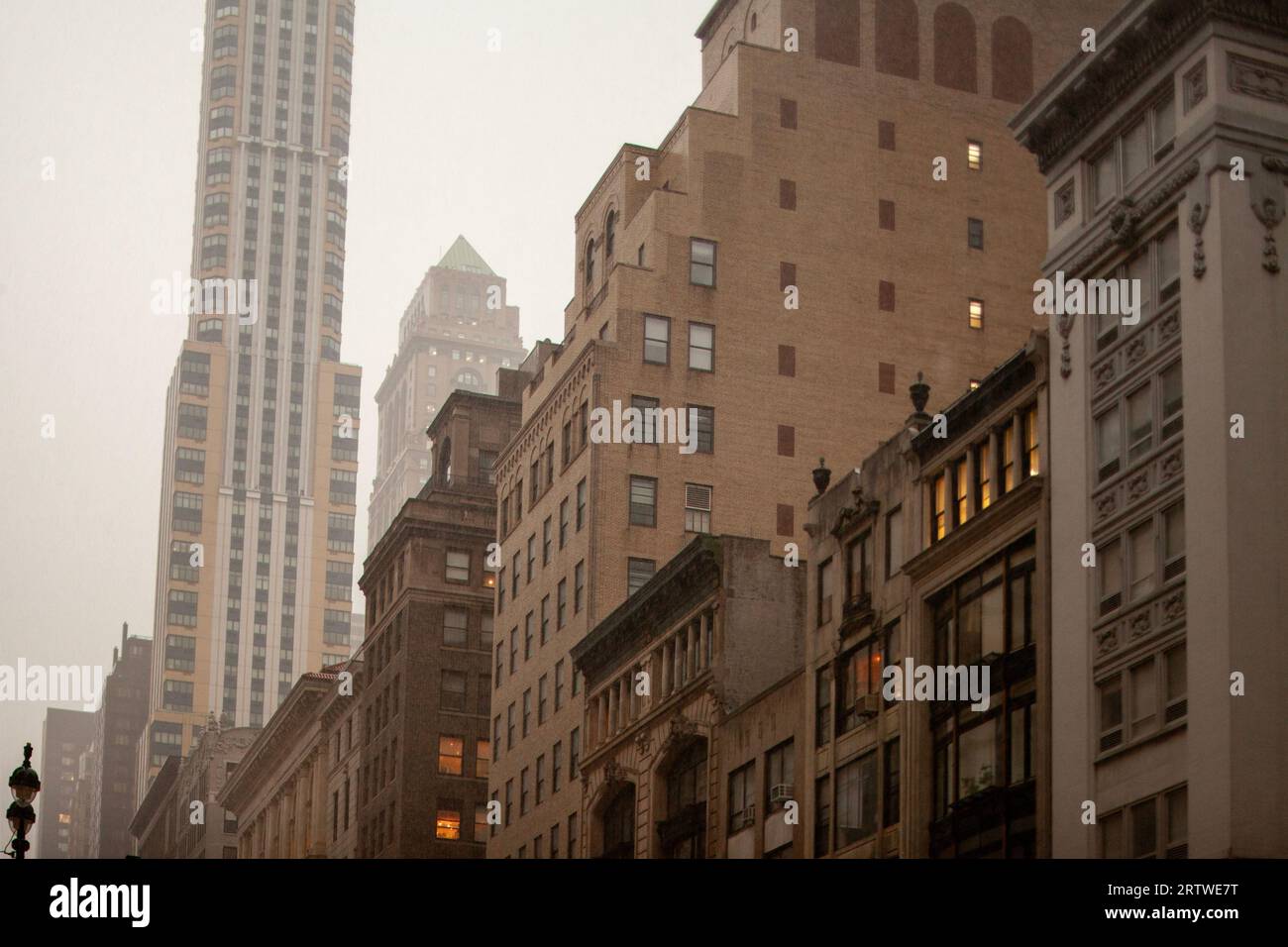 Verschiedene New Yorker Stadthäuser mit Blick auf die regnerische Straße Stockfoto