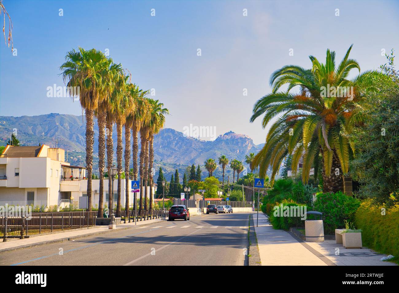 Straße in Recanati, einer Stadt in der Nähe von Giardini Naxos, mit Taormina im Hintergrund, sizilien, Italien Stockfoto
