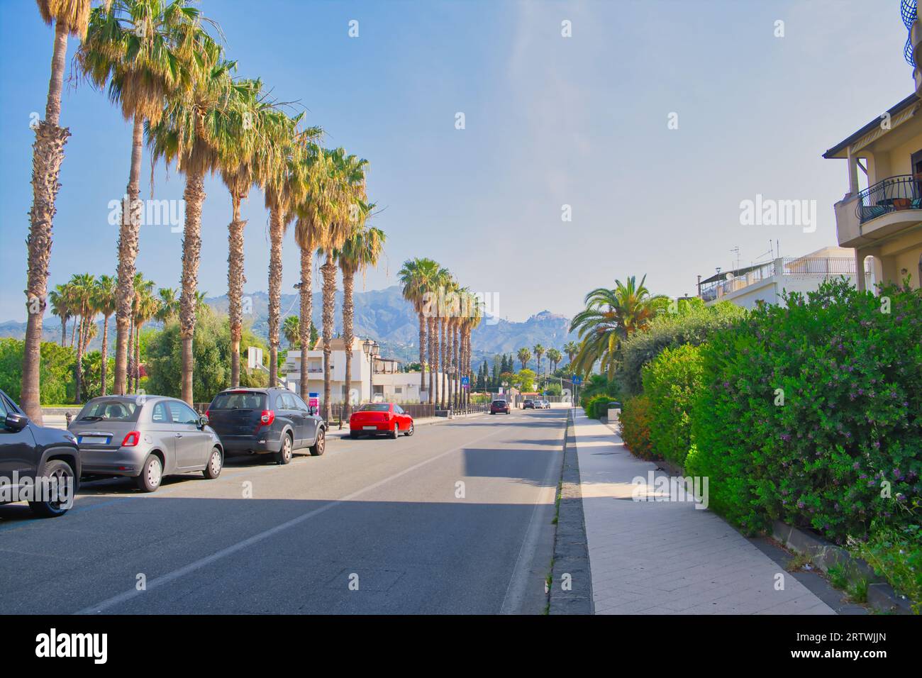 Straße in Recanati, einer Stadt in der Nähe von Giardini Naxos, mit Taormina im Hintergrund, Sizilien, Italien Stockfoto