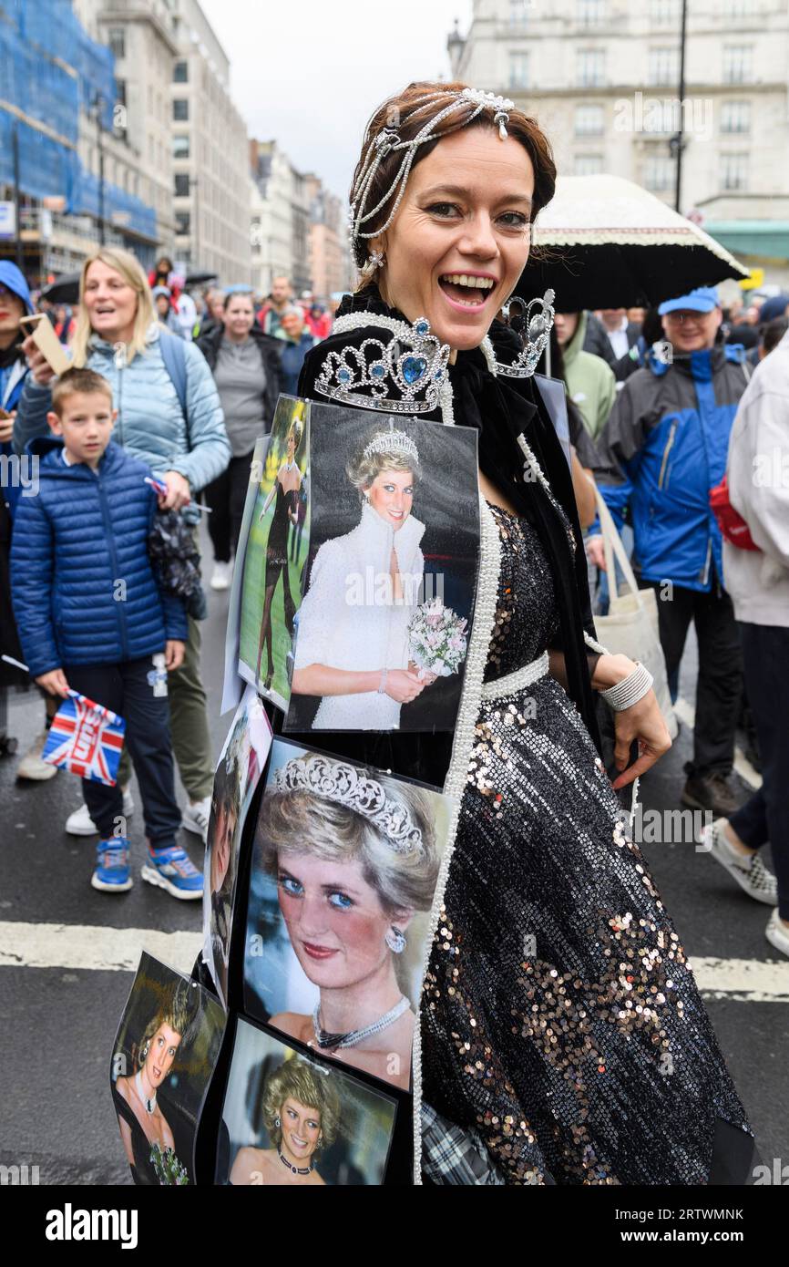 Eine Frau, die ein Abendkleid mit Fotos der verstorbenen Prinzessin Diana trägt, geht Piccadilly im Regen hinunter, ein Teil der großen Menschenmenge steuert Stockfoto
