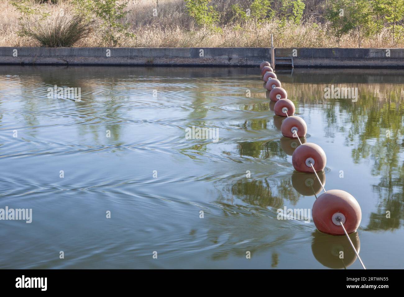 Bojenseil über die Strömung des Bewässerungskanals gestreckt. Las Vegas Altas del Guadiana, Badajoz, Extremadura, Spanien. Stockfoto
