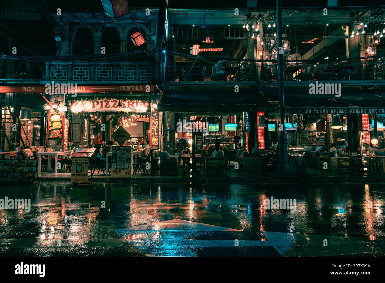 Eine nasse Nacht bringt die Farbe in den Straßen von Siem Reap zum Ausdruck. Die Lichter von Bars und Restaurants spiegeln sich auf den Straßen wider. Stockfoto