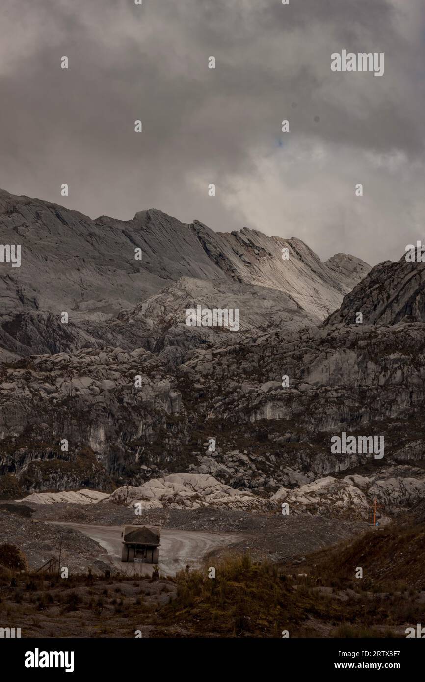 Große Lastwagen gegen die raue Landschaft in den Bergen in der Nähe des Tagebaus Grasberg in Papua, indonesische Hochländer Stockfoto