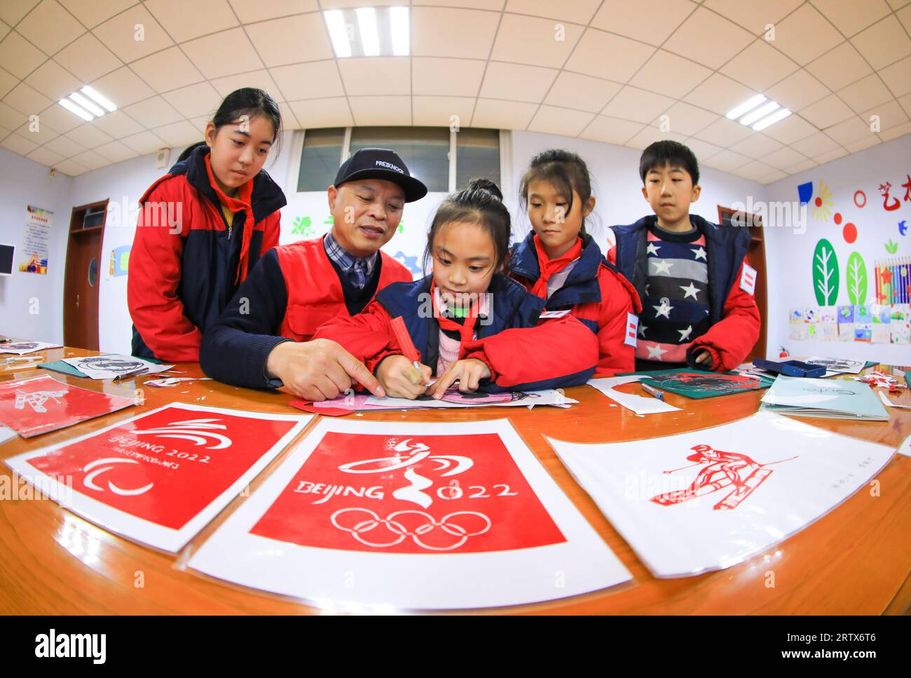 LUANNAN COUNTY, China - 10. Dezember 2021: Grundschüler lernen traditionelle chinesische Papierschneidekunst unter der Leitung von Lehrern, Nord-C Stockfoto