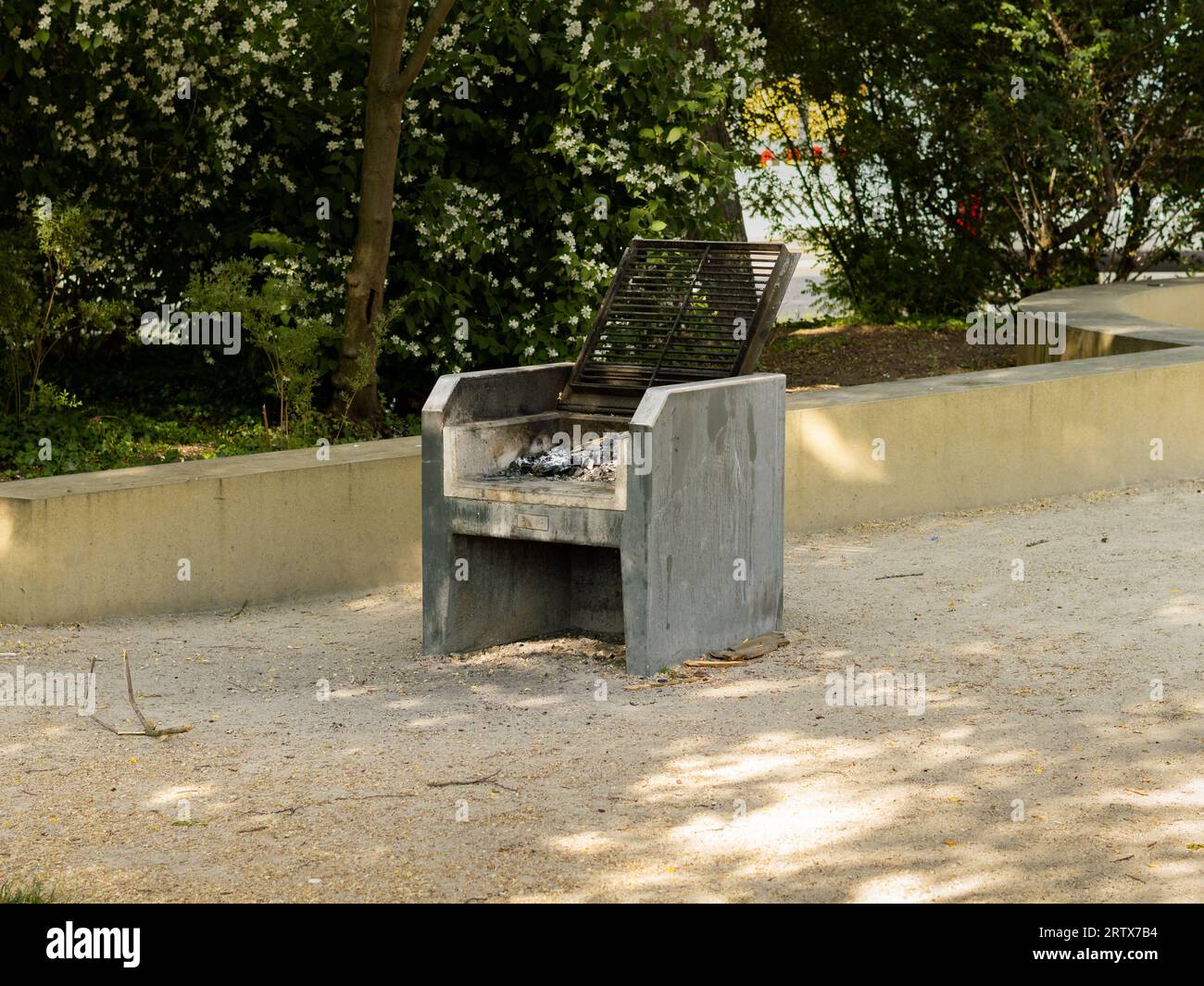 Öffentliche Grillausrüstung in einem Park. Der Steinblock ermöglicht es Menschen, Speisen im Freien zu grillen. Kamin für eine Grillparty. Stockfoto