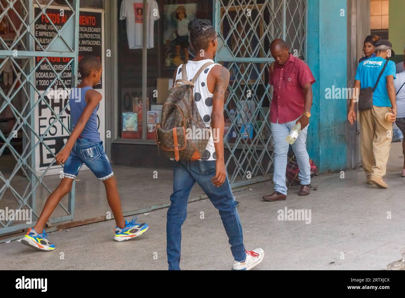 Havanna, Kuba, 2023, kubanische Menschen gehen auf einem Bürgersteig in der Stadt. Das Stadtleben und der Lebensstil der echten Menschen auf der Karibikinsel Stockfoto