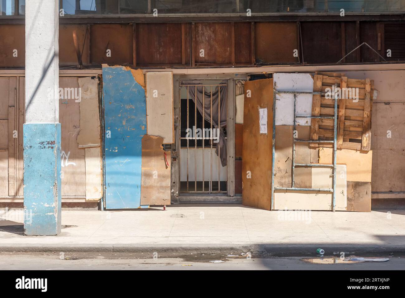 Havanna, Kuba, 2023, Eine Mauer eines Gebäudes mit verschiedenen Pappstücken und anderen Materialien. Rustikale Konstruktion durch ein Metallgitter, das ein entra schützt Stockfoto