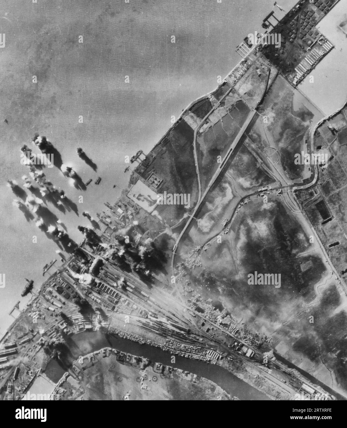 Bomben, die von der Boeing B-29 „Superfortresses“ von General Curtis E. Lemays 20Th Bomber Command Burst on Shipping und dem Tientsin-Pukow Railroad Terminal am Ostufer des Yangtze River gegenüber der Stadt Nangking, China, abgeworfen wurden Stockfoto