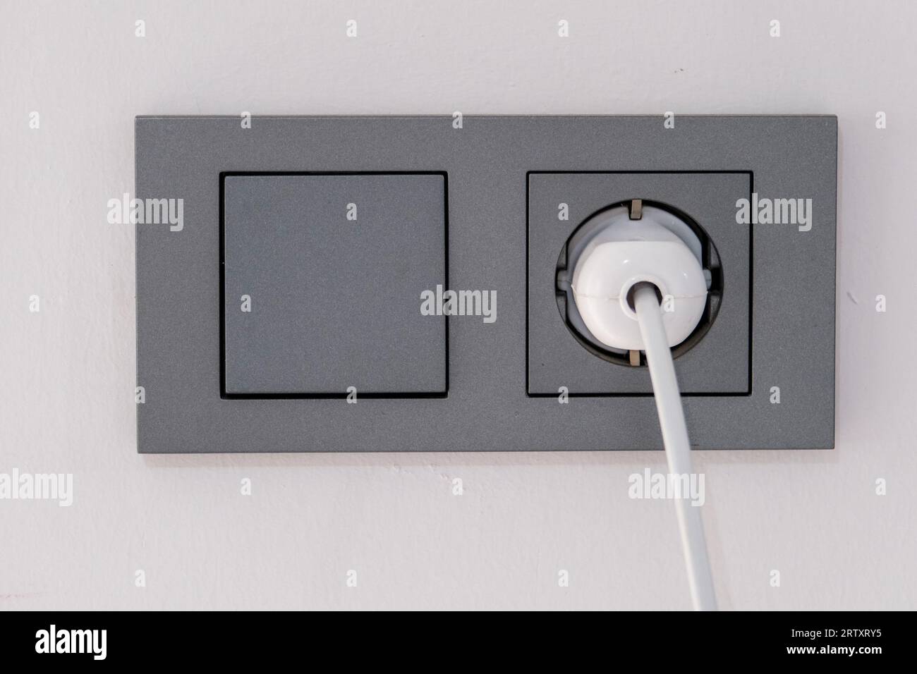 Nahaufnahme Lichtschalter und Steckdose an der Wand. Stockfoto