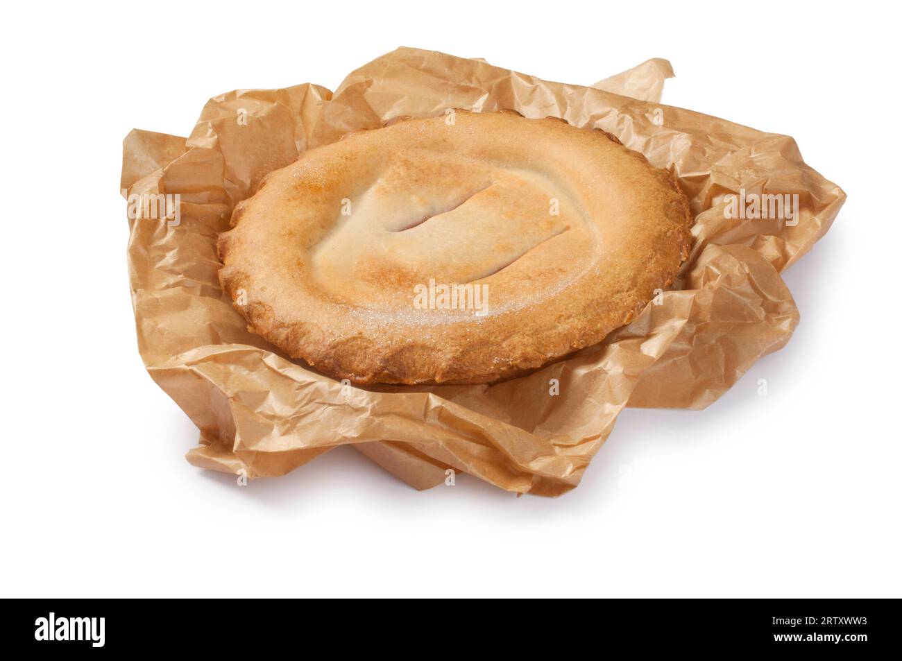 Studio-Aufnahme von einem ganzen Obstkuchen in Backpapier, ausgeschnitten auf weißem Hintergrund - John Gollop Stockfoto