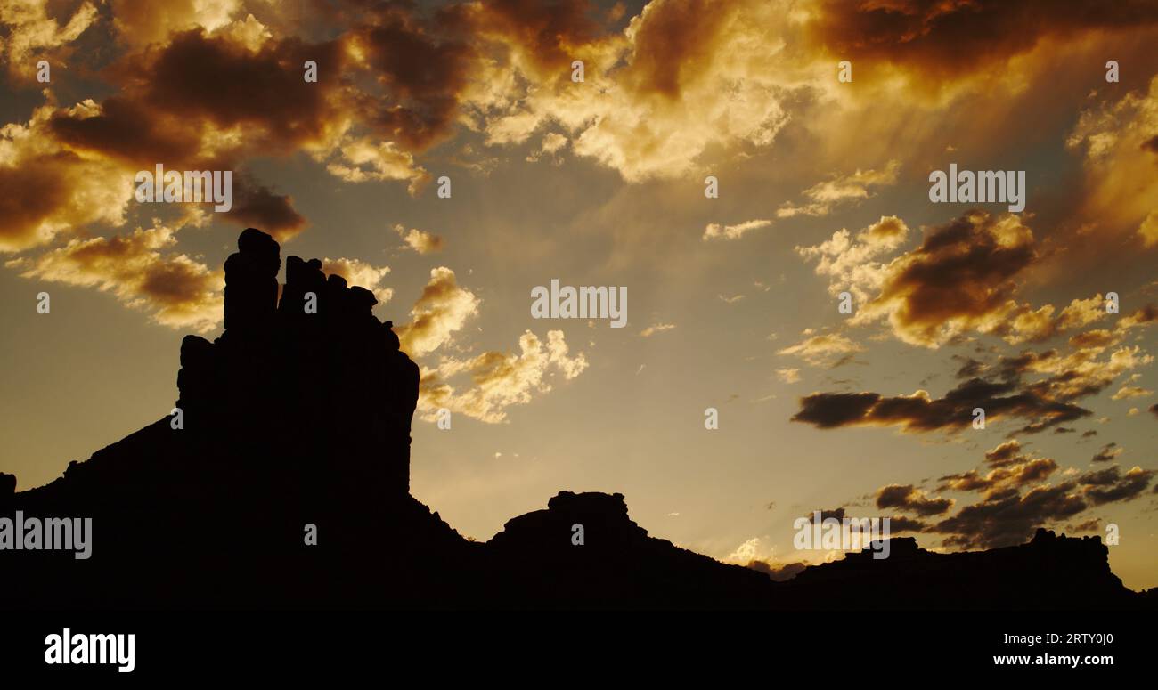 Wüstenbutten und unheimliche Sandsteintürme an einem wunderschönen goldenen Abend im Valley of the Gods, Utah. Stockfoto