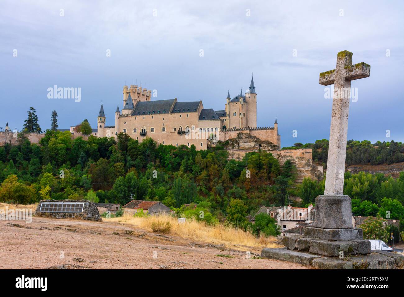 Segovia, Spanien. 15. September 2022 - Alcazar von Segovia auf dem felsigen Hügel mit Klippen, vom Steinkreuz neben der Templer-Kirche im Tal Stockfoto
