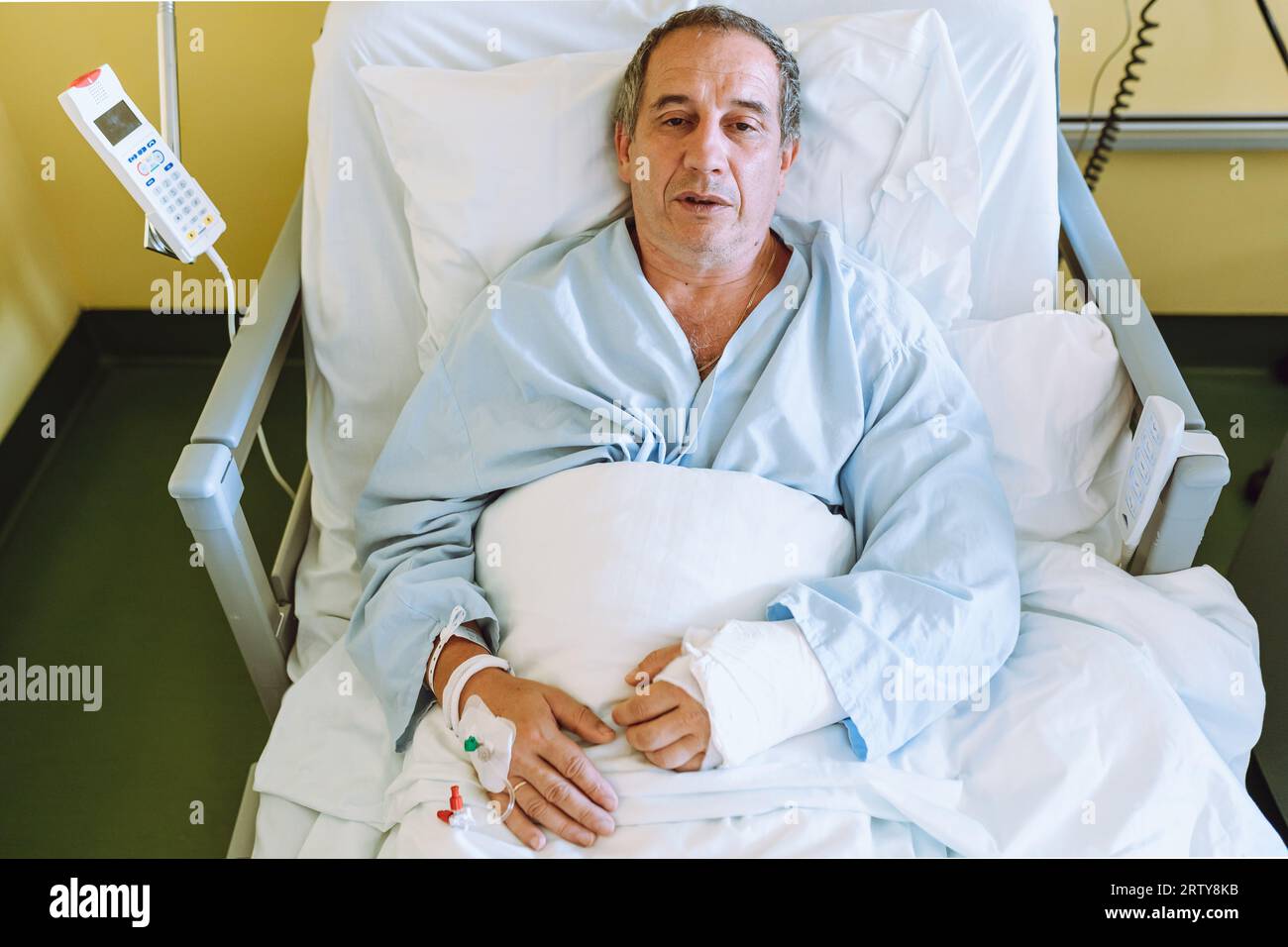 Männlicher Patient nach Verletzung oder Operation auf der Krankenhausstation Stockfoto