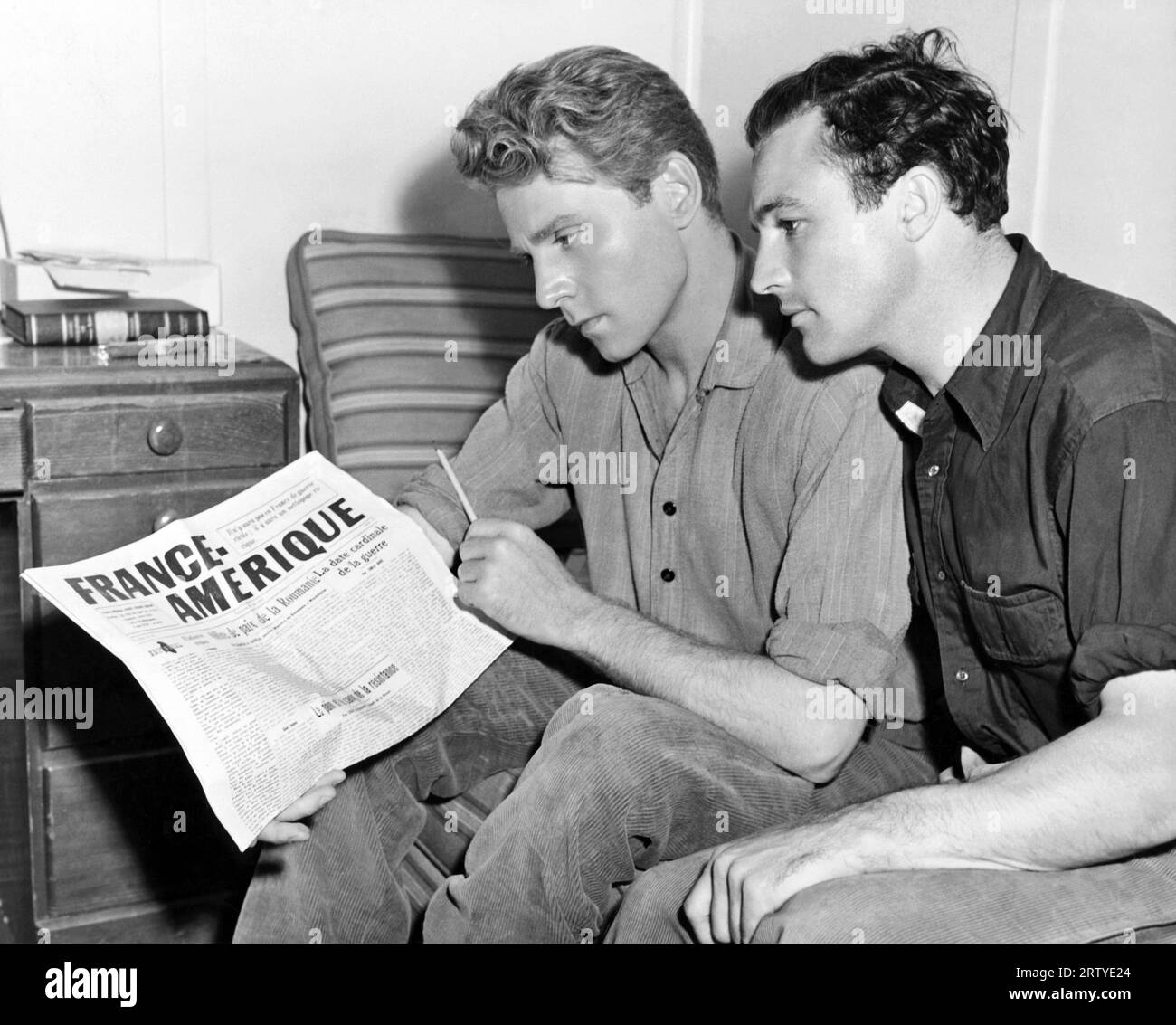 Hollywood, Kalifornien: 1943 Schauspieler Jean Pierre Aumont (L) und Gene Kelly (R) machen Pause in den Dreharbeiten zum MGM-Film „The Cross of Lorraine“. Kelly berührte Aumont Dance Steps und Aumont kehrt die Gunst zurück, indem er Kelly beibringt, Französisch zu sprechen. Stockfoto