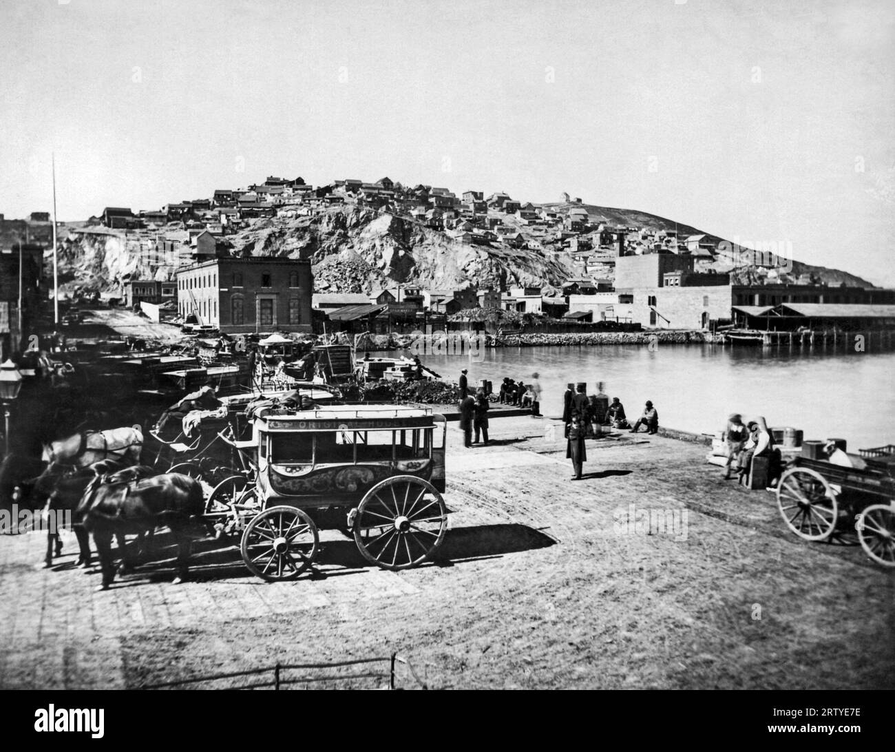 San Francisco, Kalifornien: c. 1855 Blick auf den Broadway mit Clarke's Point Warehouse auf der rechten Seite an der Front Street und der originalen Hotelkutsche im Vorgarten. Stockfoto