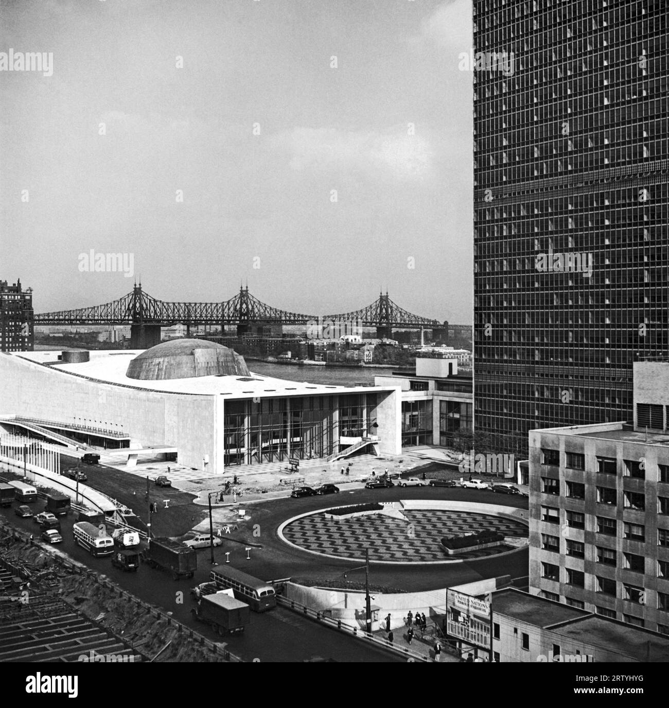 New York, New York um 1952 die neuen Gebäude der Vereinten Nationen in Midtown Manhattan, mit dem East River und der Queensboro Bridge im Hintergrund. Das Foto zeigt den UN-Platz und den ornamentalen Brunnen. Stockfoto