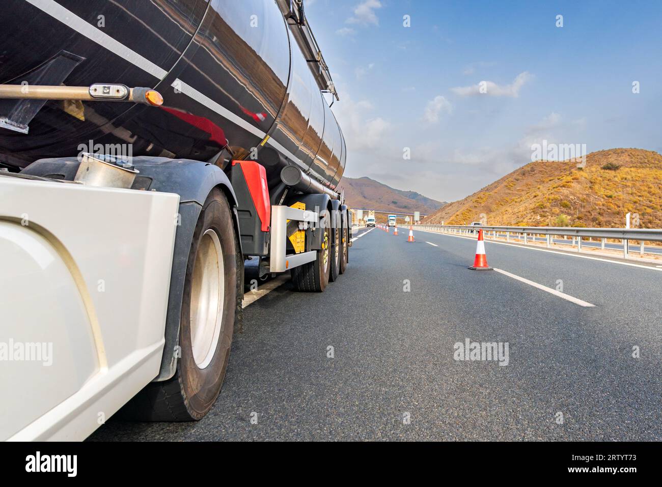 Defekter Tanklastwagen auf der Autobahn mit Kegeln, die vom Autobahndienst aufgestellt wurden, um die stark befahrene Fahrbahn abzuschneiden. Stockfoto