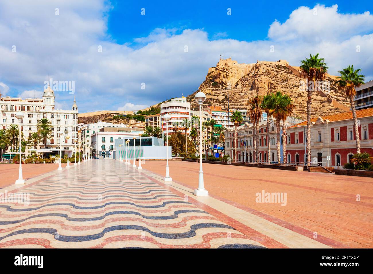 Hafenplatz und Schloss Santa Barbara im Hintergrund. Santa Barbara Castle ist eine Festung auf dem Mount Benacantil im Zentrum von Alicante, Spanien. Stockfoto