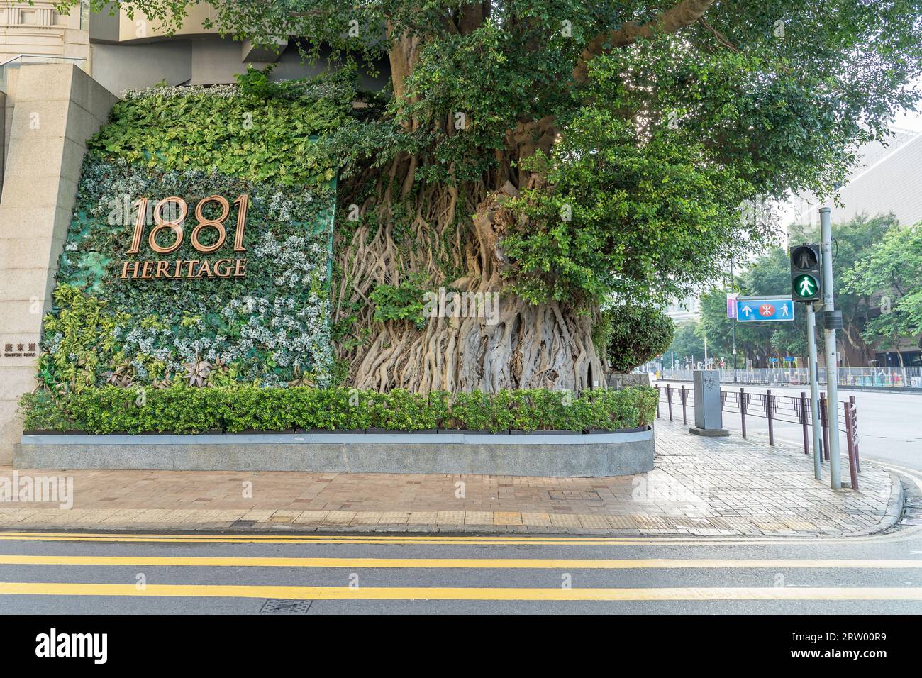 Schild und Baum an der Ecke der Straße Werbung 1881 Heritage Luxury Shopping plaza an einem sonnigen Tag in Tsim Sha Tsui. Hongkong Stockfoto