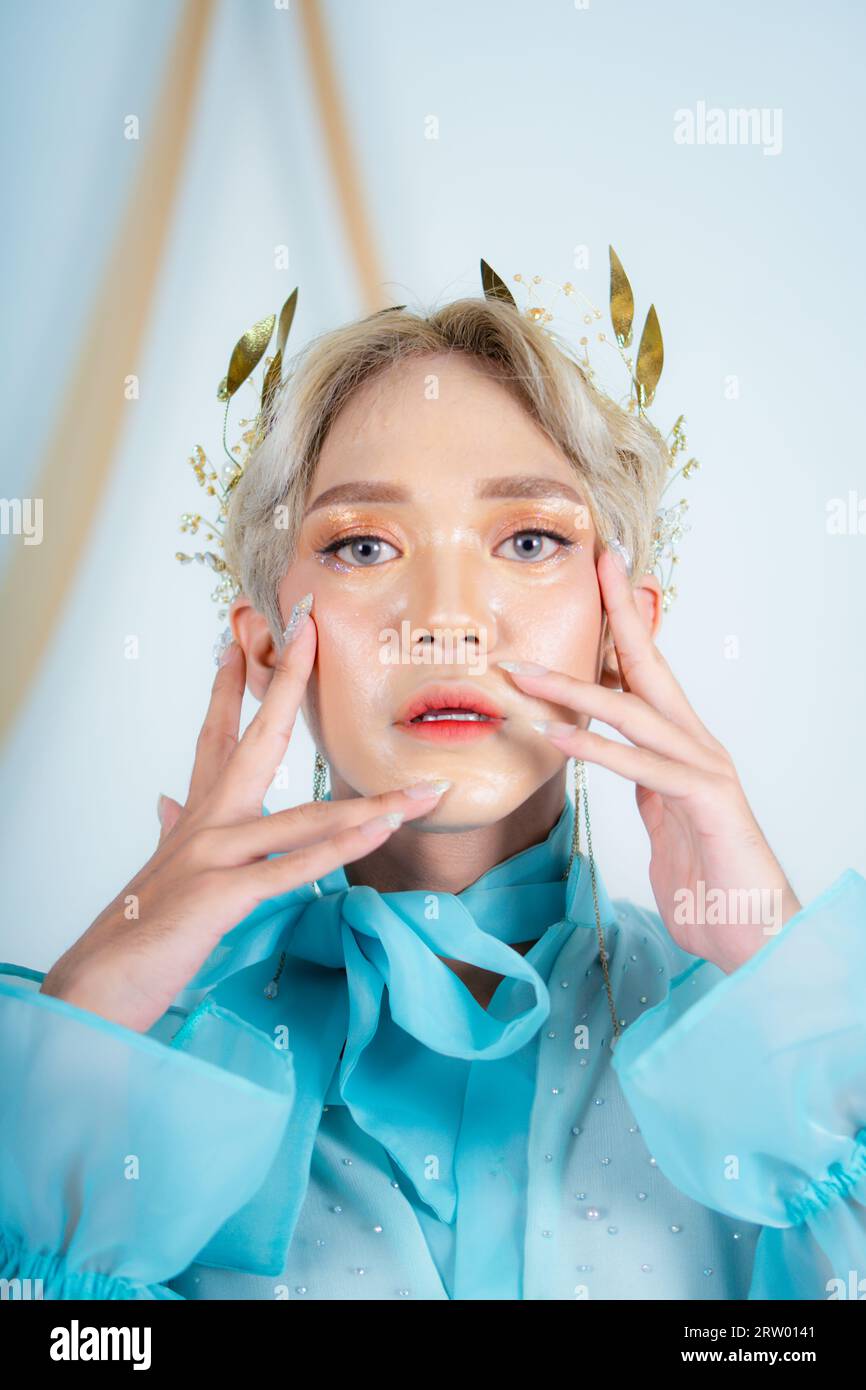 Schönes Gesicht einer asiatischen Frau mit rotem Lippenstift und blauen Augen in einem weißen Studio Stockfoto