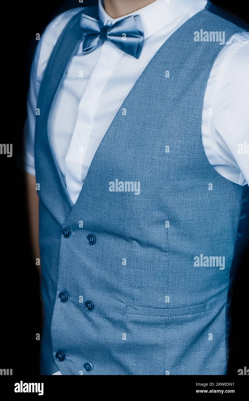 Herrenmode Mode Mode Mode Mode blaue Weste und Schleife mit weißem Hemd auf dunklem Hintergrund. Stockfoto