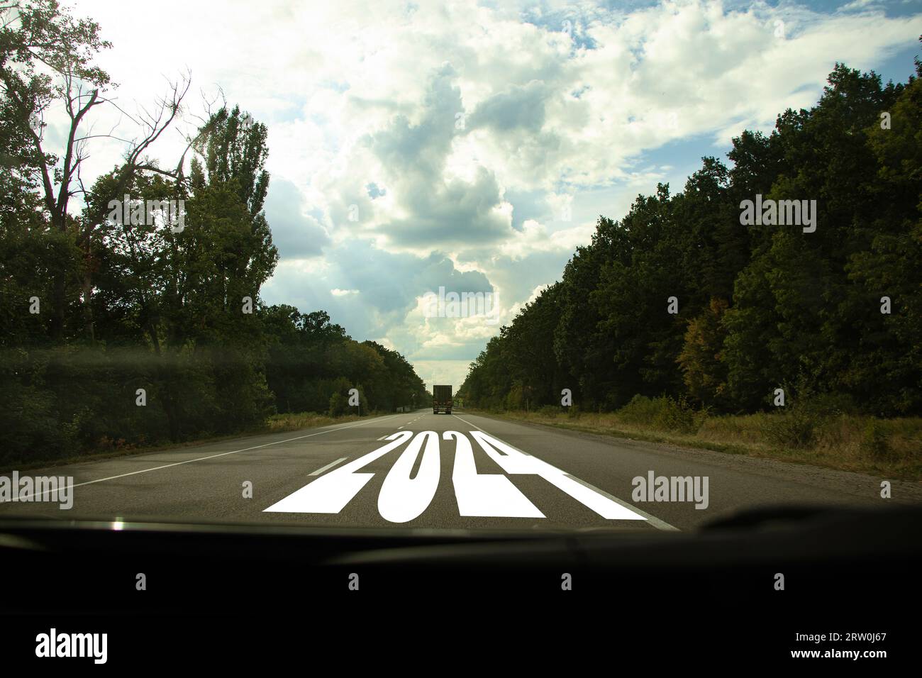 Das Jahr 2024 ist auf der Straße auf der Autobahn geschrieben, Blick von einem fahrenden Auto auf der Straße in der Ukraine, frohes neues Jahr 2024 Stockfoto