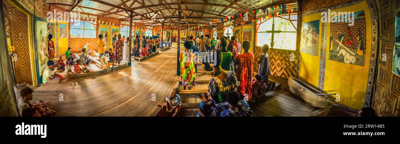 Palembe, Papua-Neuguinea, Juli 2015: Panoramabild von Ureinwohnern, die während der Messe in der Kirche in Palembe, dem Fluss Sepik in Papua, stehen und sitzen Stockfoto