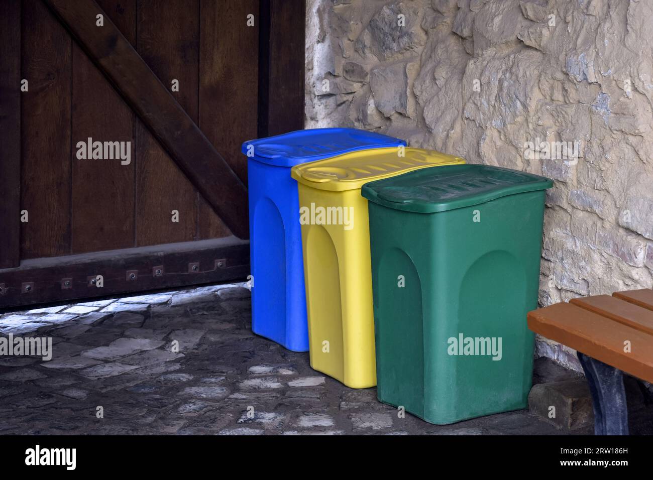 Mehrfarbige Kunststoffbehälter zur separaten Müllsammlung. Das Konzept des Umweltschutzes vor Verschmutzung. Leerzeichen kopieren. Selektiver Fokus. Stockfoto