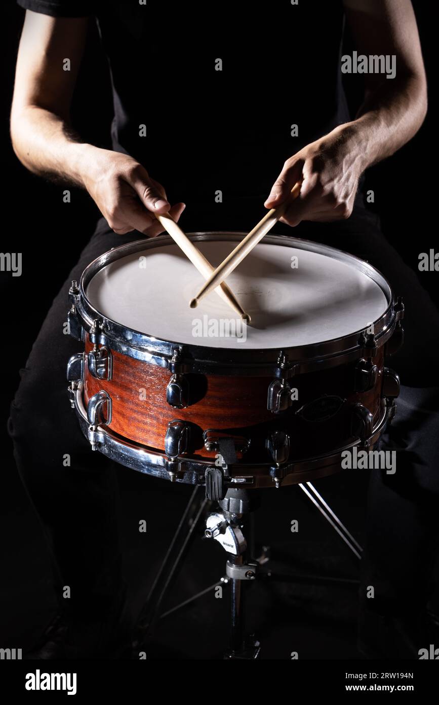 Mann spielt musikalische Schlaginstrument mit Stöcken auf schwarzem Hintergrund closeup, ein musikalisches Konzept mit der Trommel, schöne Beleuchtung auf der Stockfoto