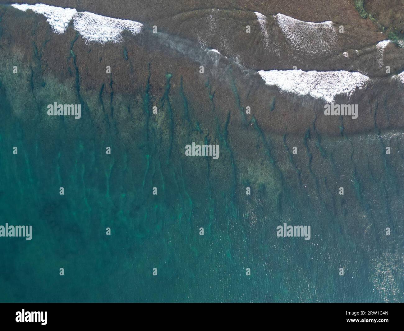 Draufsicht auf kristallklares Wasser mit Wellen, die zusammenbrechen Stockfoto