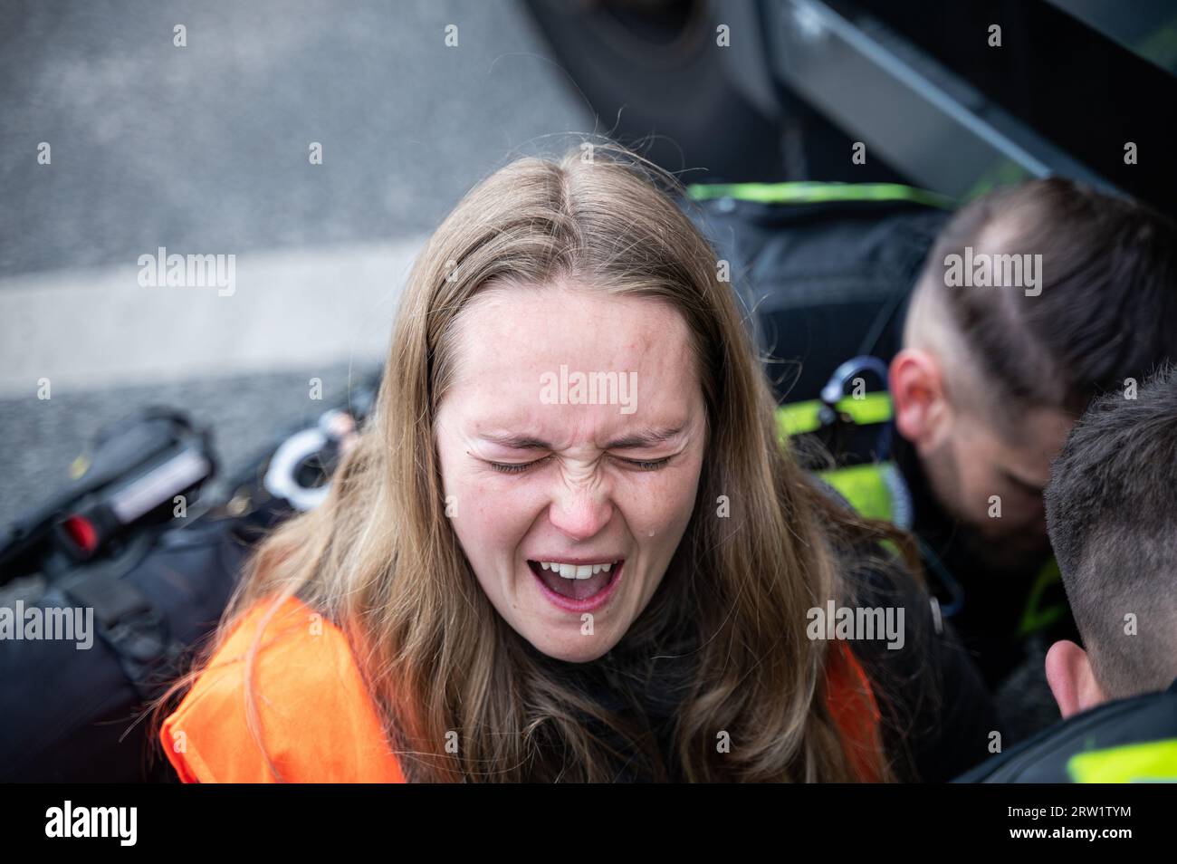 28.04.2023, Deutschland, Berlin, Berlin - Europa - mit Hilfe von Speiseoel lösen Berliner Polizeibeamte vorsichtig die Hand einer letzten Generation clima Stockfoto