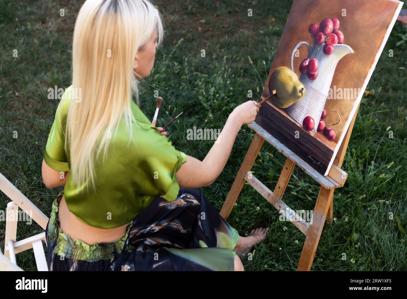 Junge, blonde Frau malte in ihrem Atelier. Stockfoto