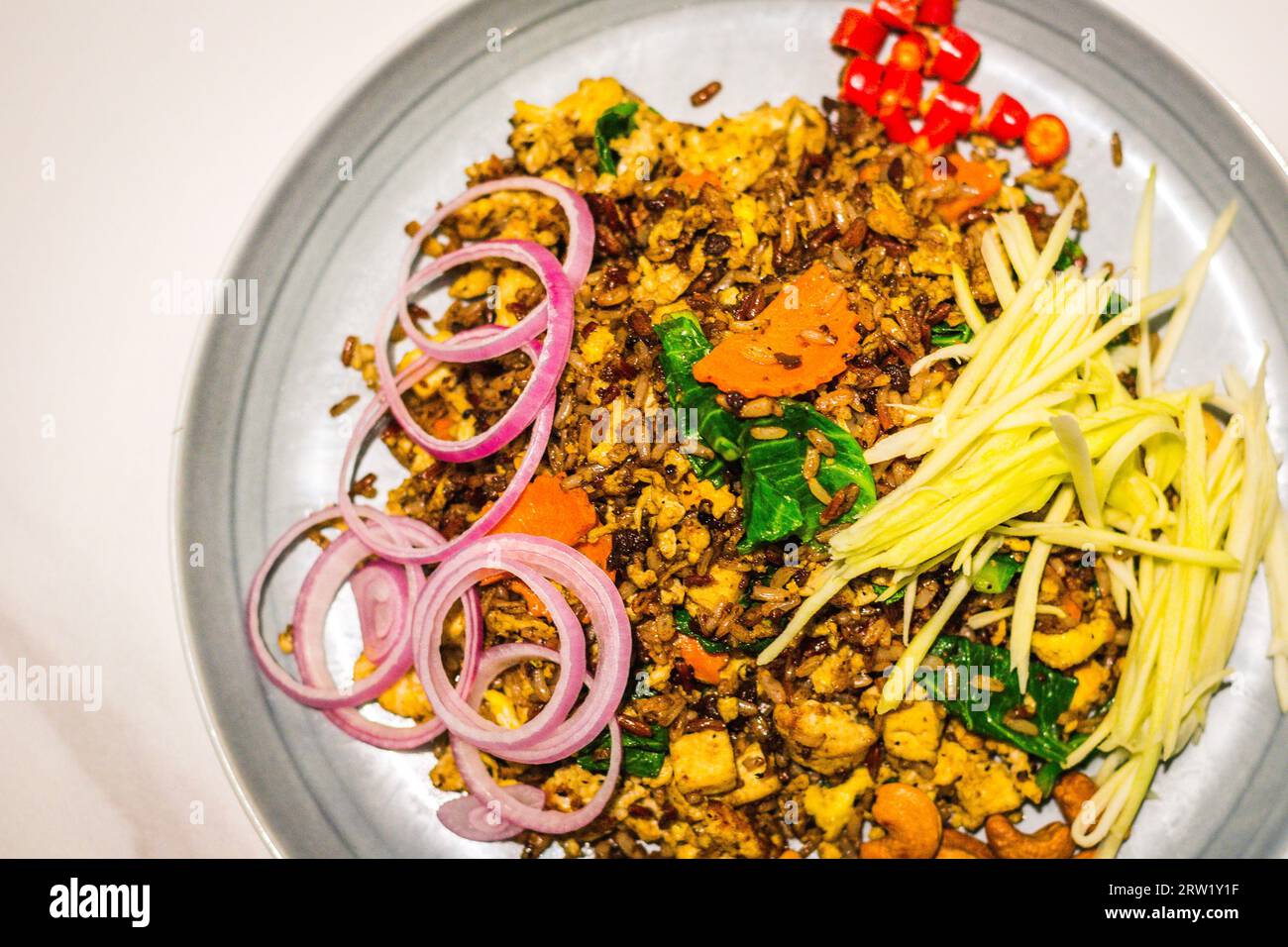 Thai Olive Organic Reis (Vegan) frittierter Reis im Isan-Stil mit grünen Mangos, Zwiebeln, Chili padi und unmöglichem Fleisch Stockfoto