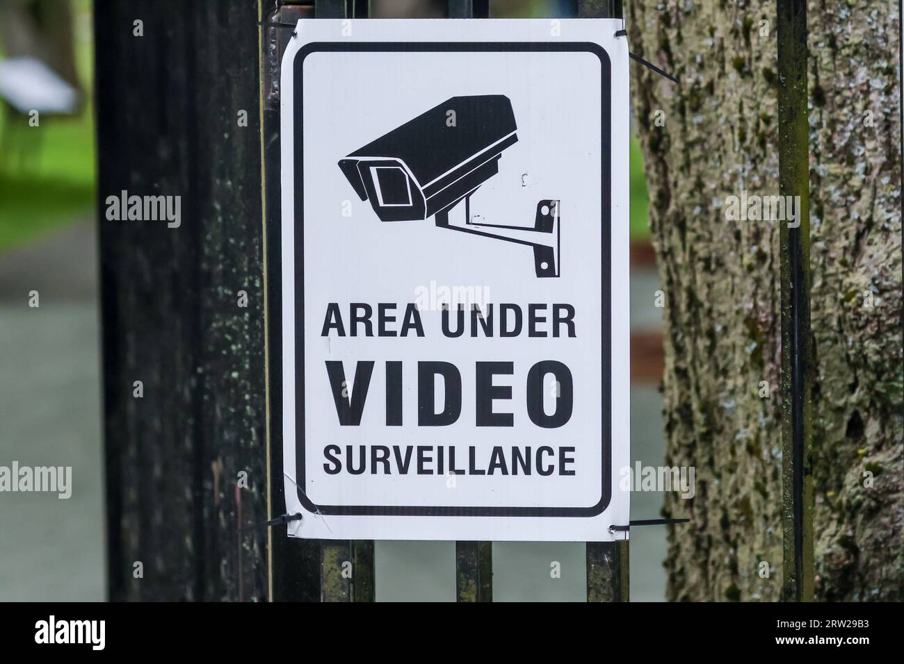 Bereich unter Videoüberwachung Warnschild mit Abbildung der Kamerahalterung an der Wand, schwarzer Schrift auf weißem Hintergrund Stockfoto