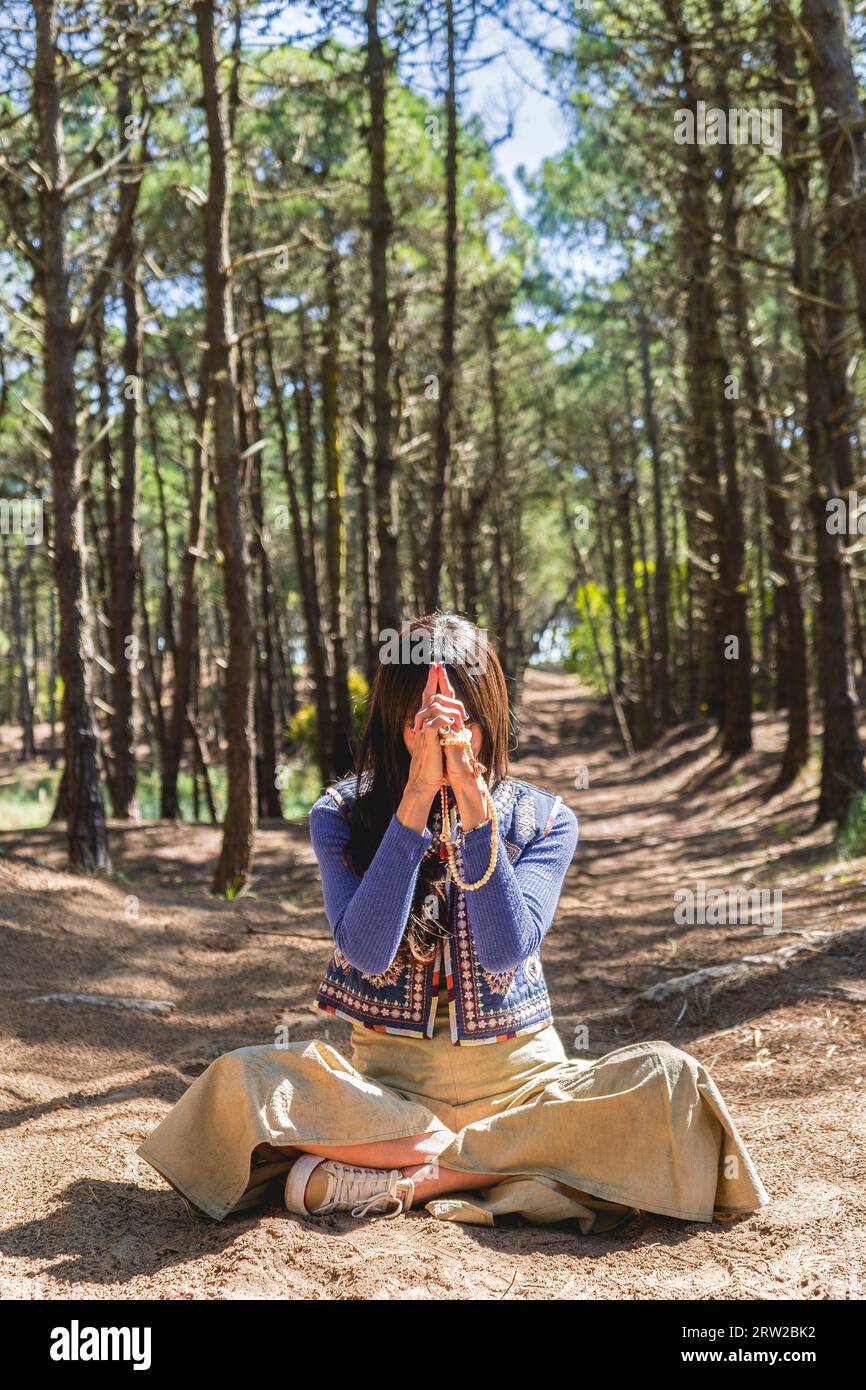 Kali mudra in Lotusstellung von einer Frau im Wald ausgeführt Stockfoto