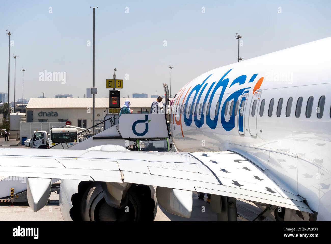 Passagiere, die eine Treppe zu FlyDubai Aircraft am Flughafen Dubai einsteigen Stockfoto