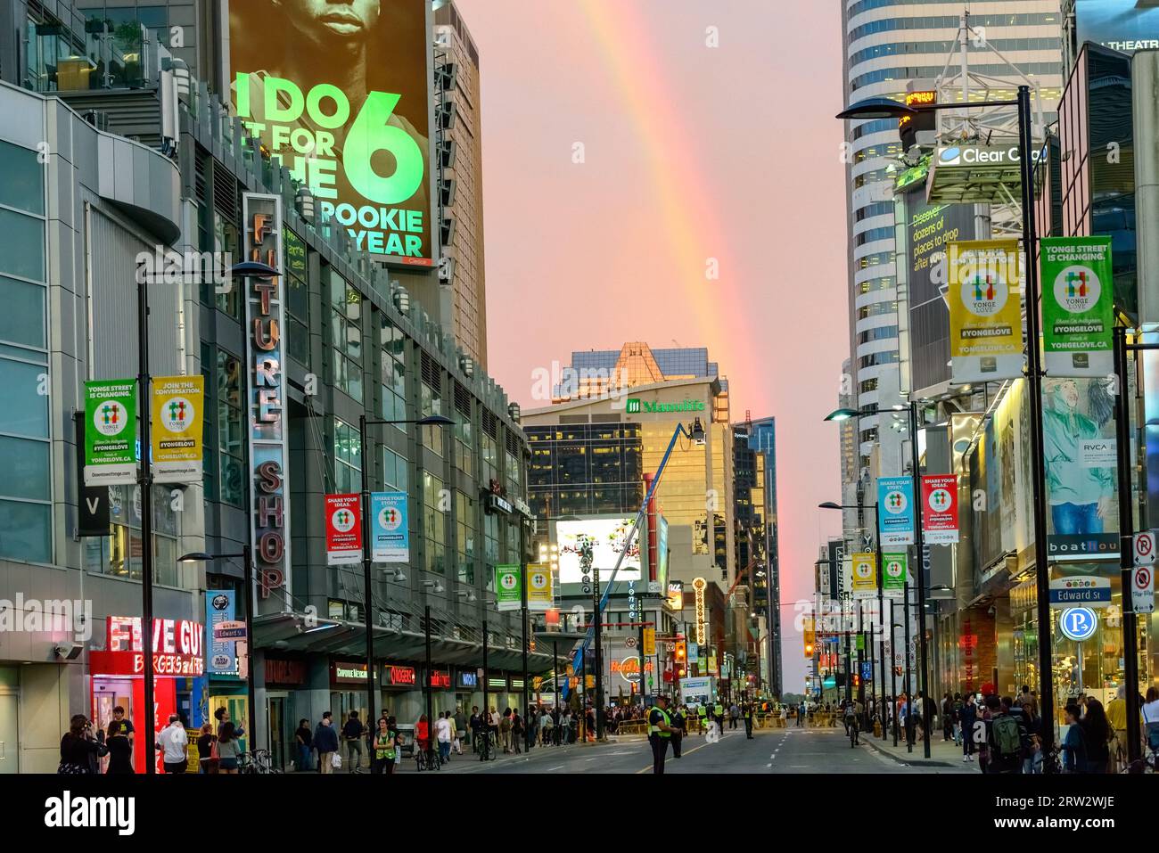 Während der Vorbereitungen für die Dreharbeiten in der Yonge St. in der Innenstadt taucht ein wunderschöner Regenbogen in der Abenddämmerung auf. Stockfoto