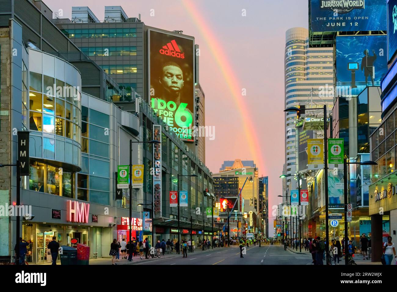 Während der Vorbereitungen für die Dreharbeiten in der Yonge St. in der Innenstadt taucht ein wunderschöner Regenbogen in der Abenddämmerung auf. Stockfoto